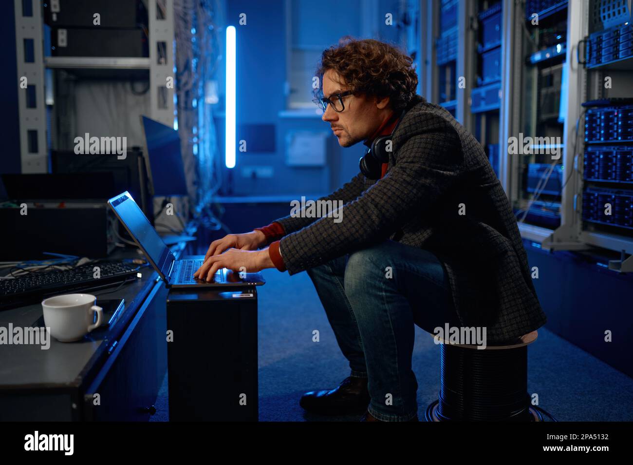 IT technician using laptop while working in data center Stock Photo