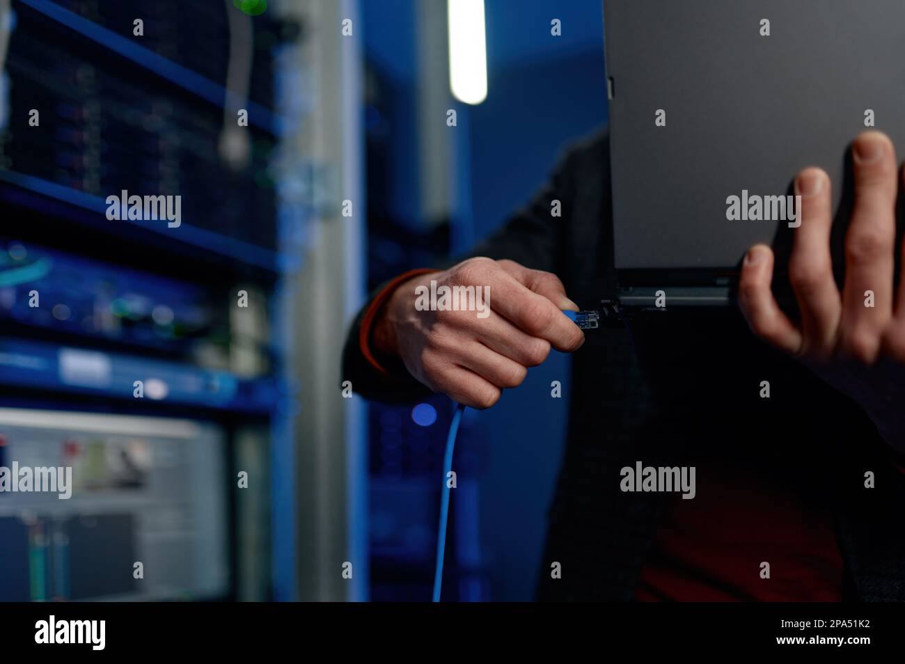 IT technician switching wire to laptop computer closeup Stock Photo