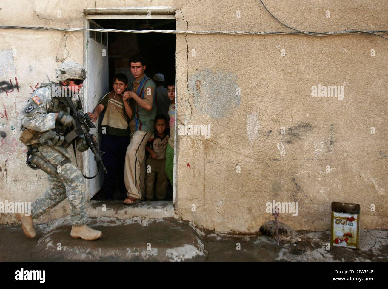 Residents react as a U.S. Army soldier from the 3rd Special Troops ...