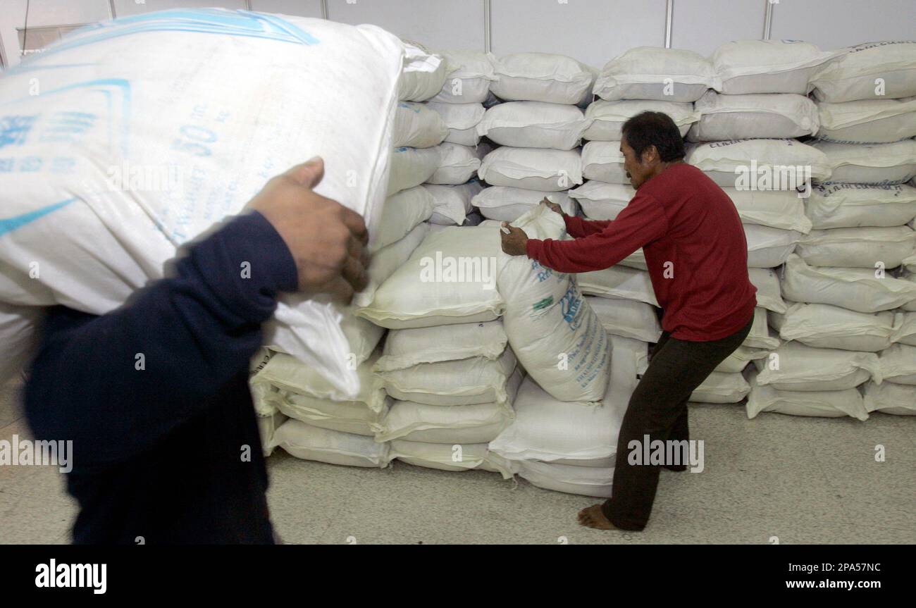 Thai workers prepare rice sacks to be sold at the Department of