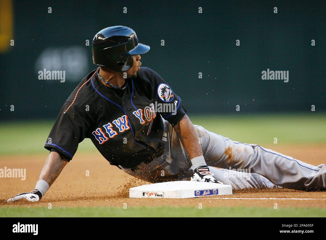 New York Mets' Jose Reyes slides into third base after hitting a triple ...