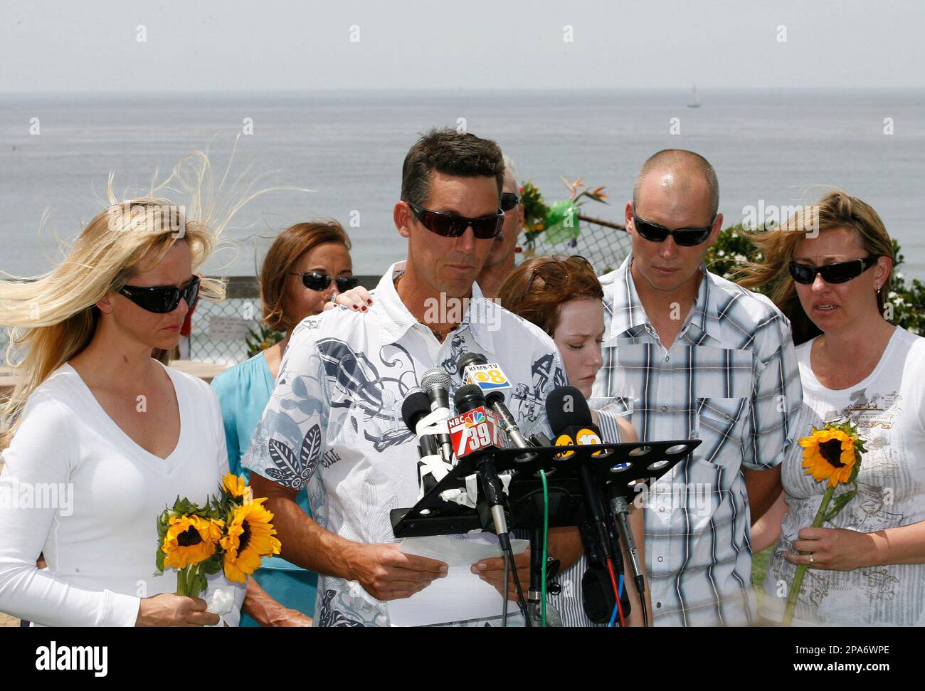 Family members listen as Jeff Martin, center, son of shark attack