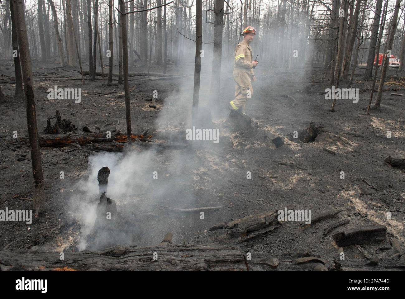 Grayling Fire Department Captain Mark McInally walks by a smoldering