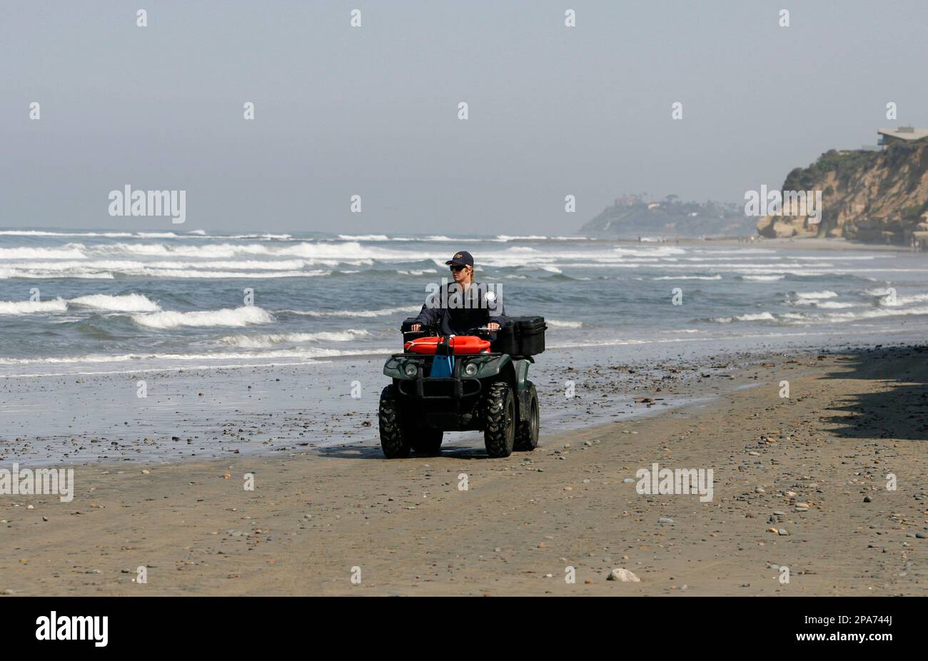 A Solana Beach lifeguard patrols the beach near where a shark attack
