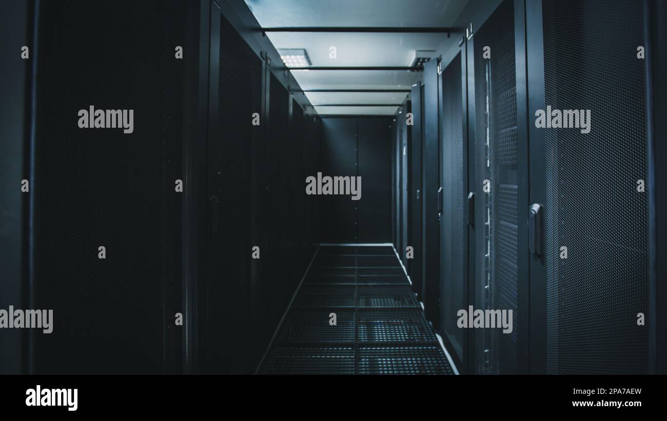 IT engineer standing before working server rack doing routine ...