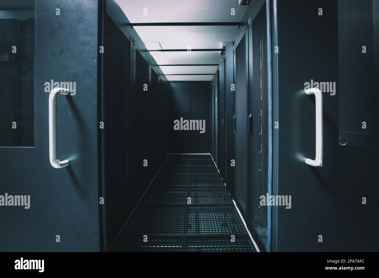 IT engineer standing before working server rack doing routine ...