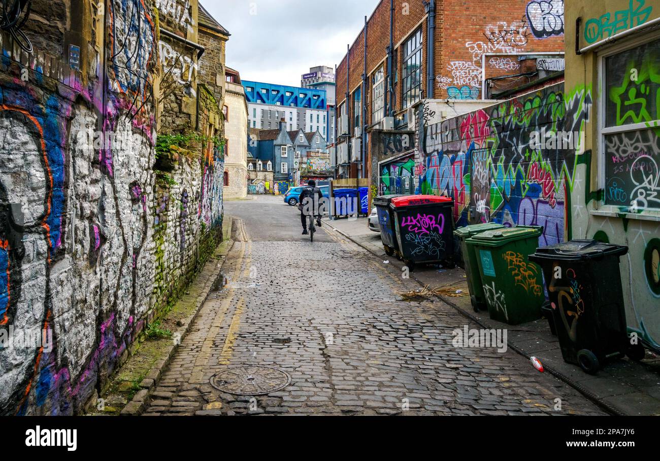Graffiti covered walls of a narrow alley in the Stokes Croft area close to the city centre of Bristol UK Stock Photo
