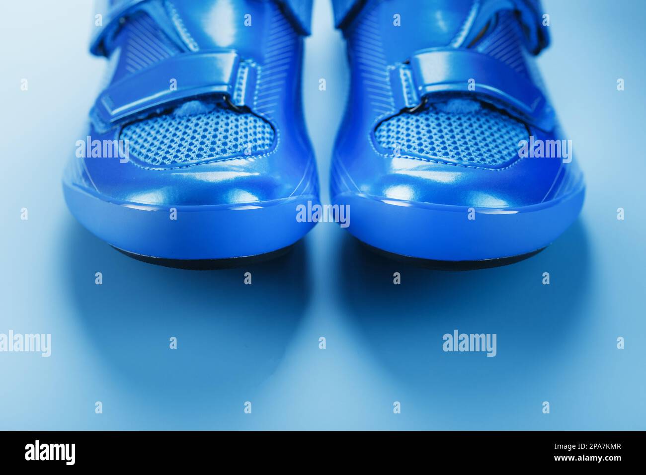 Blue Shiny Bicycle Shoes for Road Bike on Blue Background Stock Photo