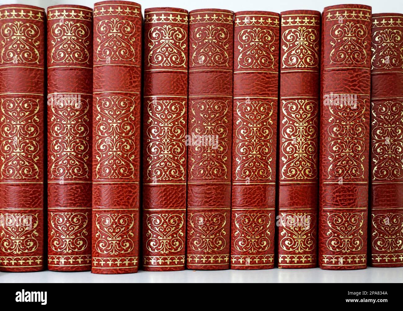 Beautiful vintage books decorated with abstract golden tendrils on red covers Stock Photo