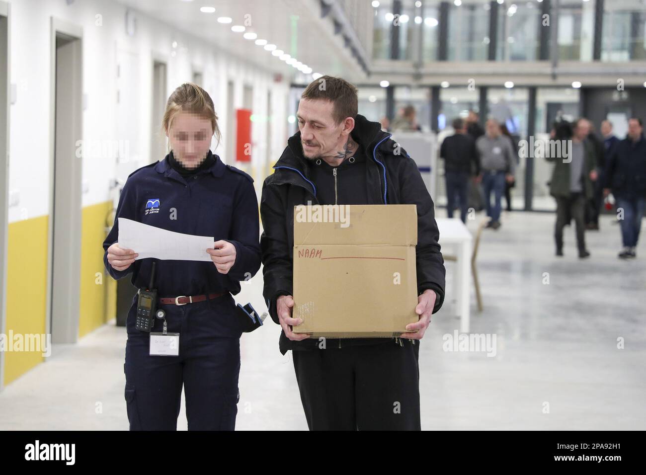 Illustration shows a prison guard and a prisoner carrying his ...