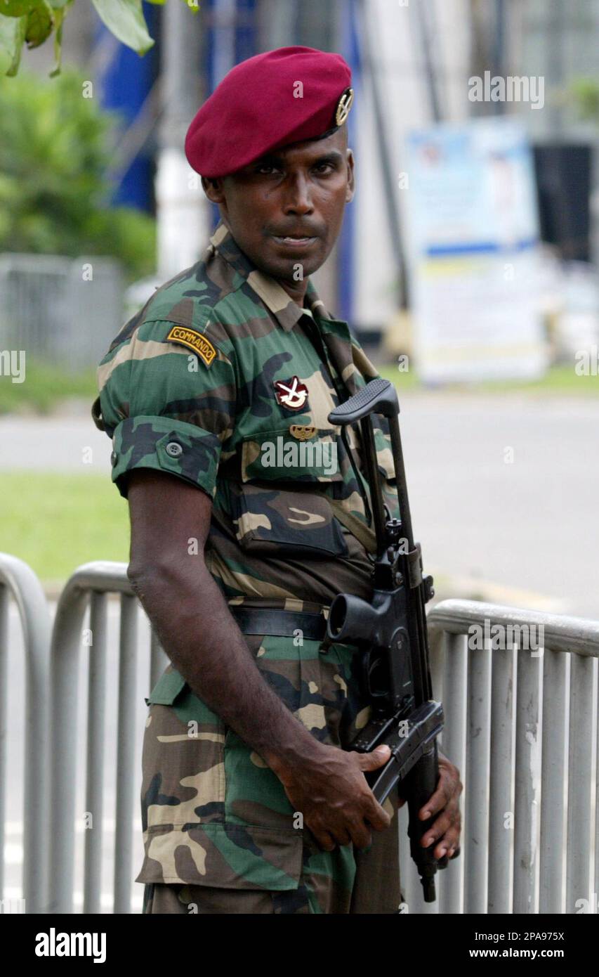 A Sri Lankan army commando stands guard outside the funeral parlor ...