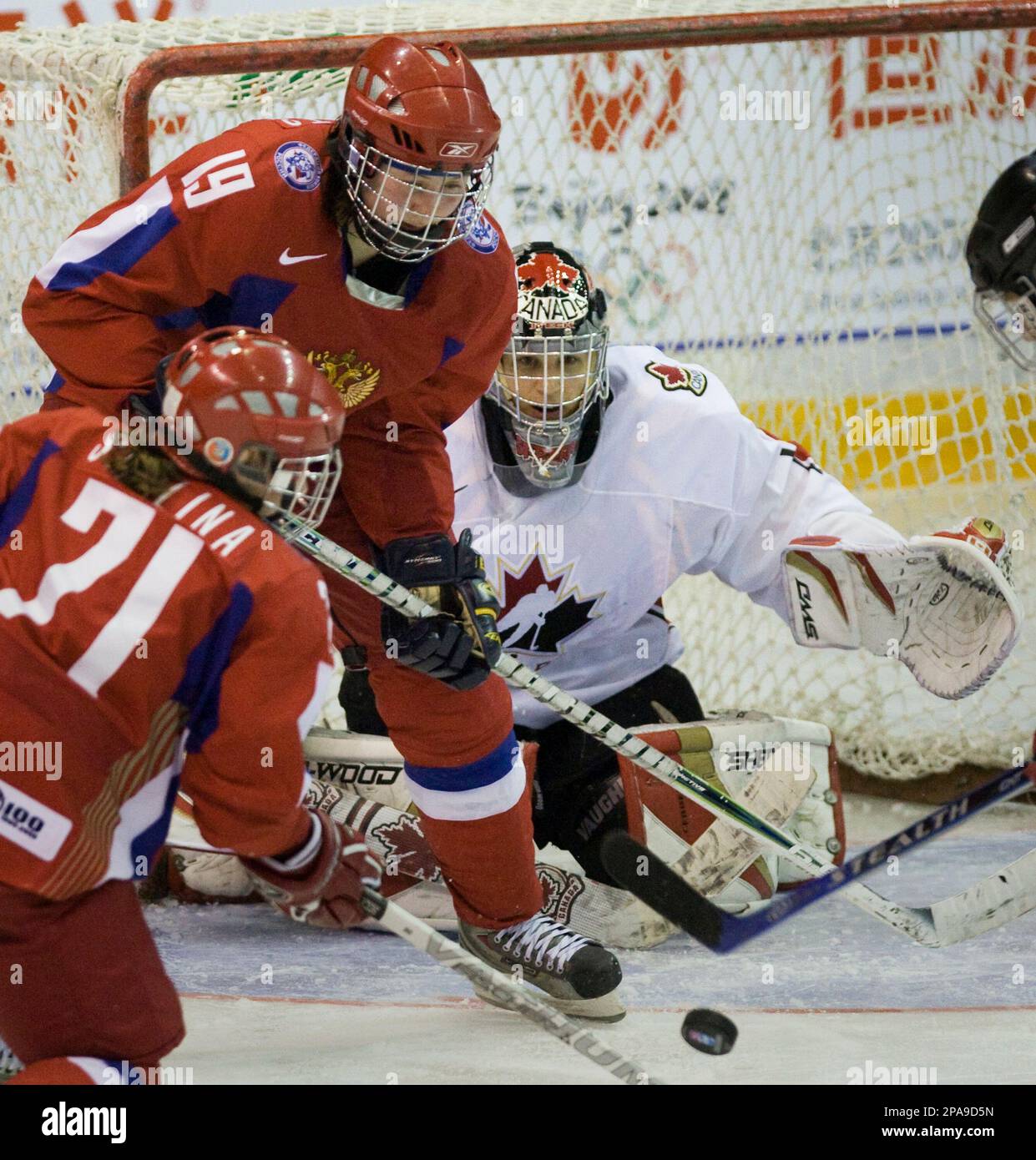 Team Canada goaltender Kim St-Pierre keeps a close eye on the puck as  Russia forwards Olga Semenets (19) and Ekaterina Smolina (71) try to get a  shot off during third period preliminary