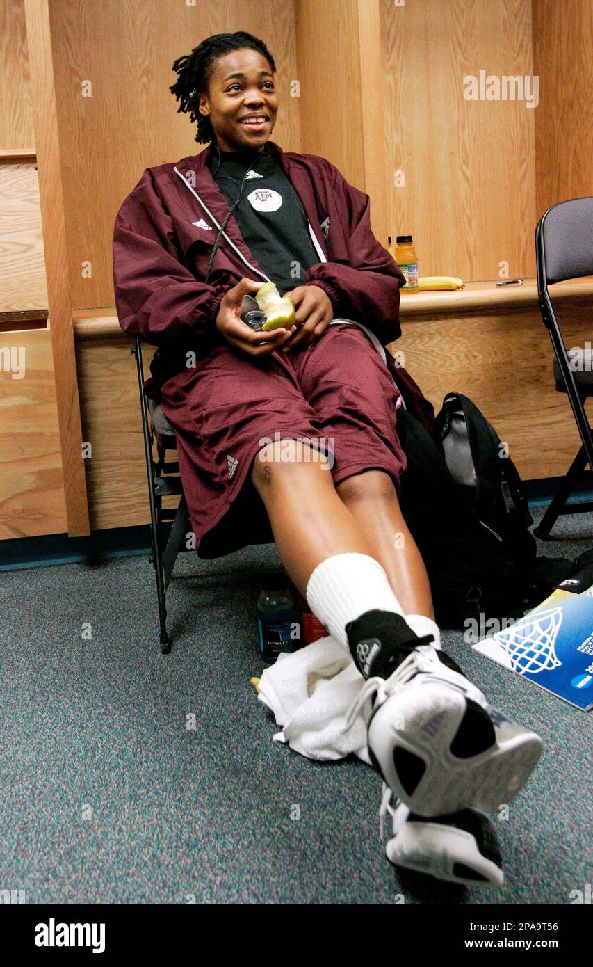 Texas A&M's Danielle Gant enjoys an apple as she responds to a reporters'  questions in the locker room following an Oklahoma City Regional NCAA  women's basketball tournament news conference, Monday, March 31,