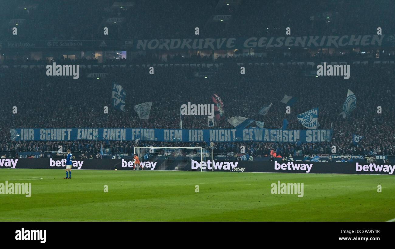 Gelsenkirchen, Germany. 11th Mar, 2023. Soccer: Bundesliga, FC Schalke 04 - Borussia Dortmund, Matchday 24, at the Veltins Arena. Schalke fans hold a banner reading 'You are creating an enemy you are no match for'. Credit: David Inderlied/dpa/Alamy Live News Stock Photo