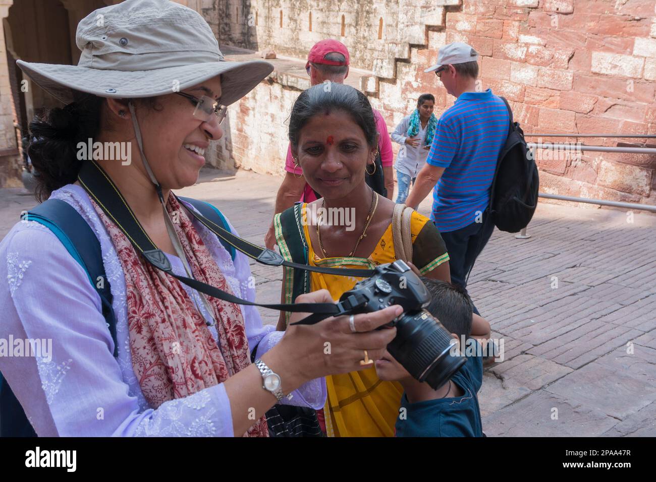 Jodhpur, Rajasthan, India - 19th October 2019 : Indian traveller female wearing modern dress showing picture on camera's LCD to Rajasthani woman. Stock Photo