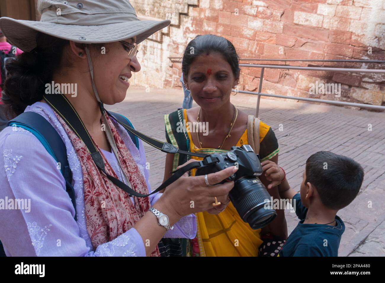 Jodhpur, Rajasthan, India - 19th October 2019 : Indian traveller female wearing modern dress showing picture on camera's LCD to Rajasthani woman. Stock Photo