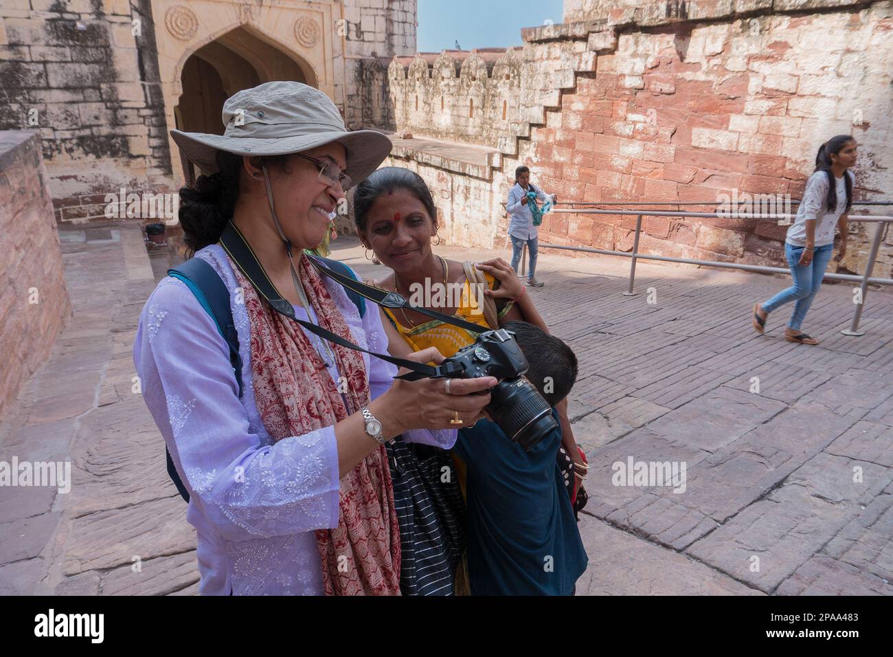 Jodhpur, Rajasthan, India - 19th October 2019 : Indian traveller female wearing modern dress showing picture on camera's LCD to Rajasthani woman. Stock Photo