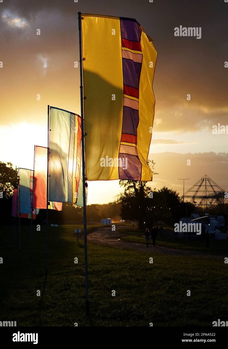 Colourful banners at Worthy Farm, Pilton, home of Glastonbury Festival, in the early evening sunset. Stock Photo