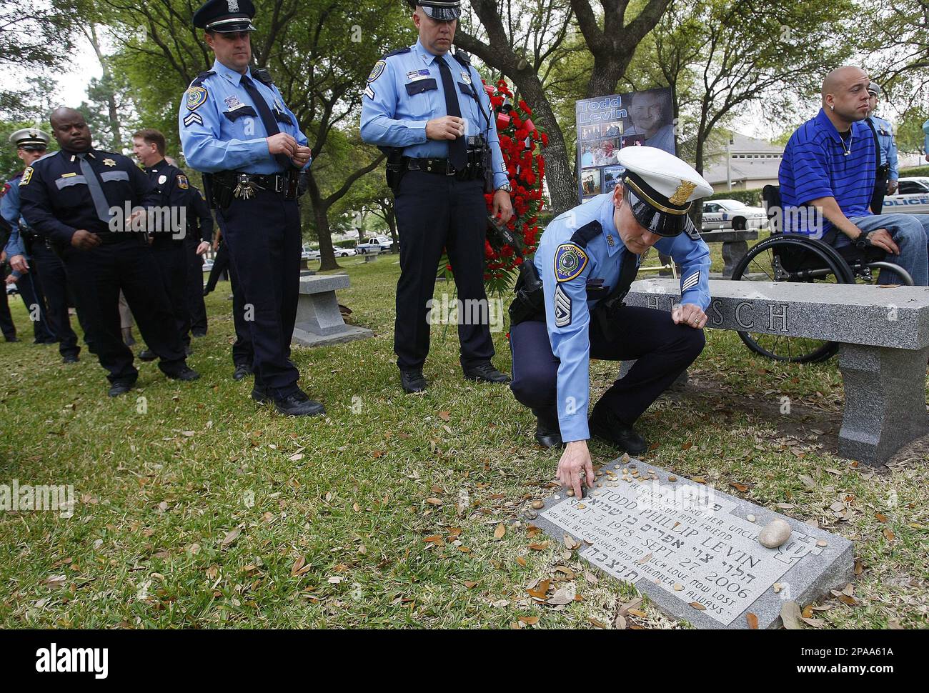 Sgt. Teresa Curry, places a pebble on the grave site of Todd Levin, a  victim killed by a drunk driver, after the Fatality Crash Reduction  Campaign news conference held at Beth Yeshurun