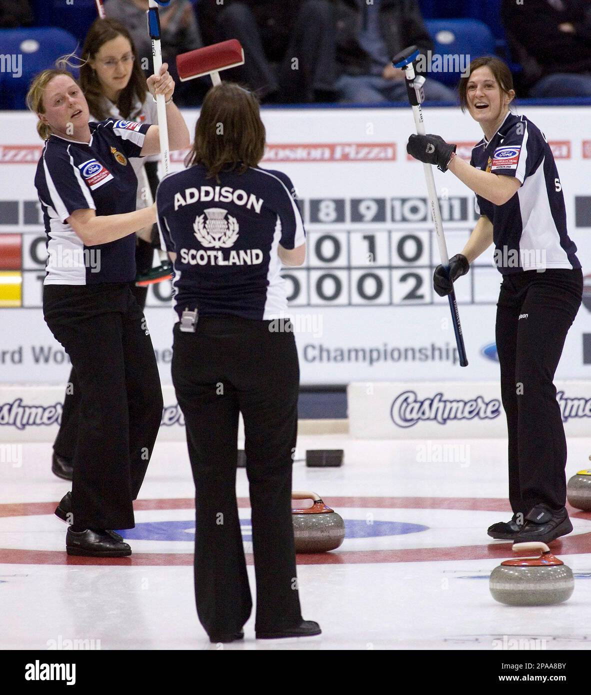 Team Scotland's skip Karen Addison, center, watches her final shot as alternate Lynn Cameron, right, and lead Anne Laird, left, celebrate their 5-4 win over Team Italy at the Women's World Curling Championships in Vernon, British Columbia, Canada, Thursday, March 27, 2008. Team Italy's skip Diana Gaspari, back second from left, looks on. (AP Photo/The Canadian Press, Jeff Bassett) Stock Photo