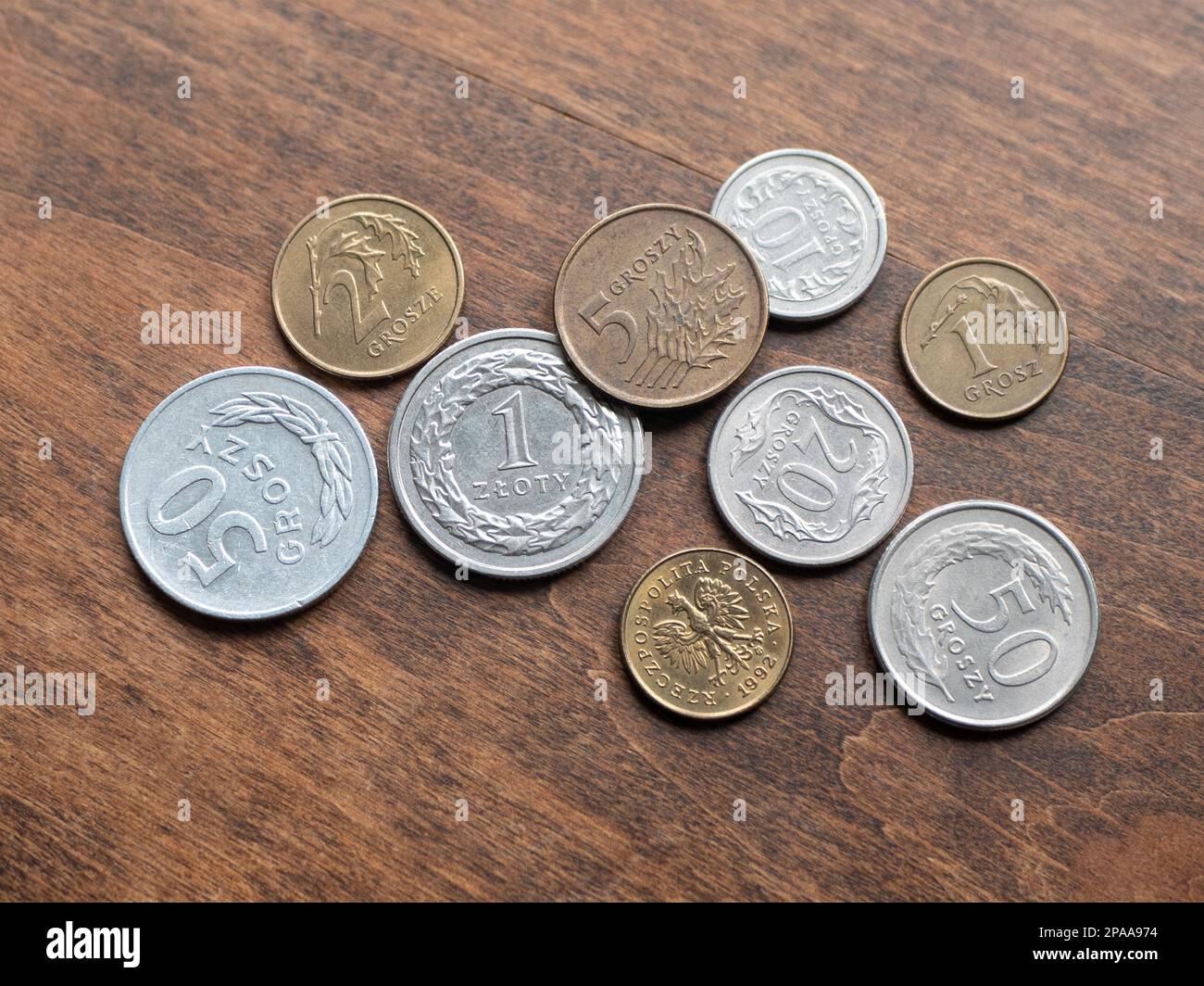 Polish metallic money on wooden table, close up. Zloty and groszy coins, selective focus Stock Photo