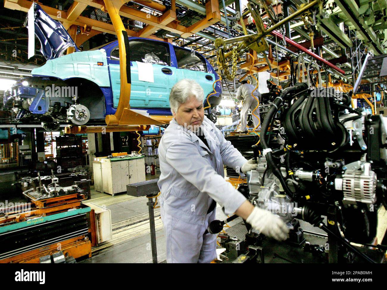 A Romanian worker checks an engine next to an assembly line in Craiova,  Romania, Friday March 21, 2008. U.S. car maker Ford Motor Co. on Friday  formally took over Romanian plant Automobile