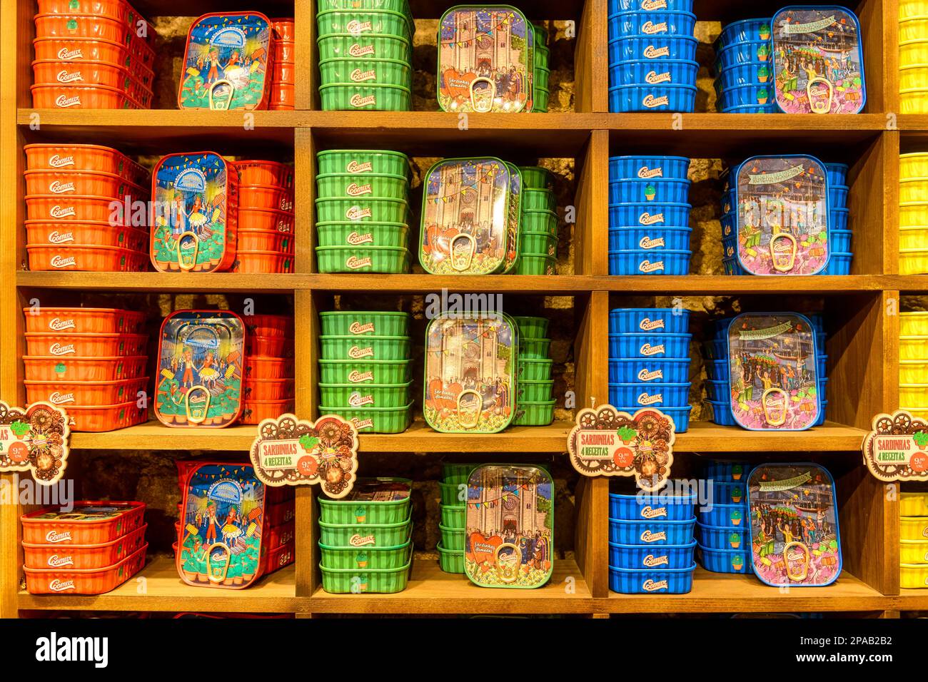 Diverse types of canned sardines in a wooden shelf inside of the