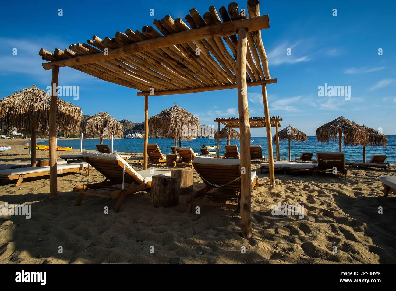 View of luxury sun beds and sun umbrellas at the famous Mylopotas beach in Ios Greece Stock Photo