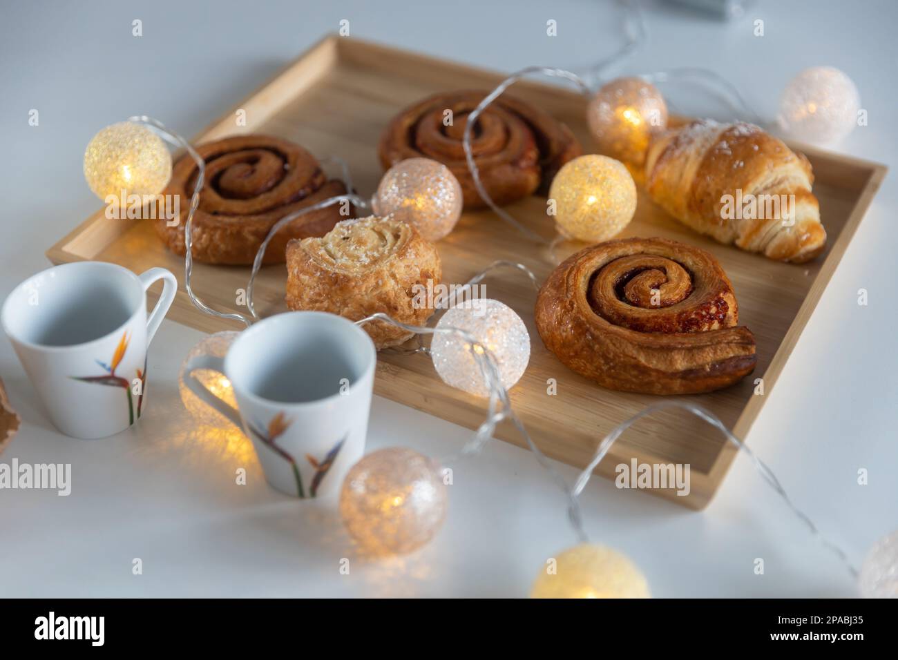 Homemade cinnamon buns with spices and caramel on tray with garland