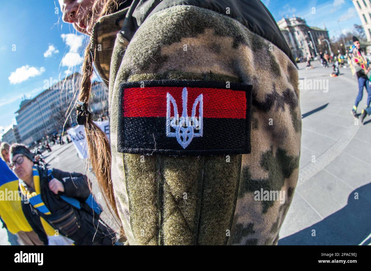 March 11, 2023, Munich, Bavaria, Germany: A red, white, and black patch which is often associated with the Organization of Ukrainian nationalists and the Stepan Bander followers. The red and the black, however, predates the era of Bandera and typically denotes the Ukrainian struggle for independence from Russia. As Russia pounds cities across Ukraine with waves of hypersonic missiles, Ukrainians and Germans in Munich, Germany made demands for peace and the immediate withdrawal of Russia from Ukrainian territory. The participants also thanked Germany and the alliance for the support for Ukraini Stock Photo