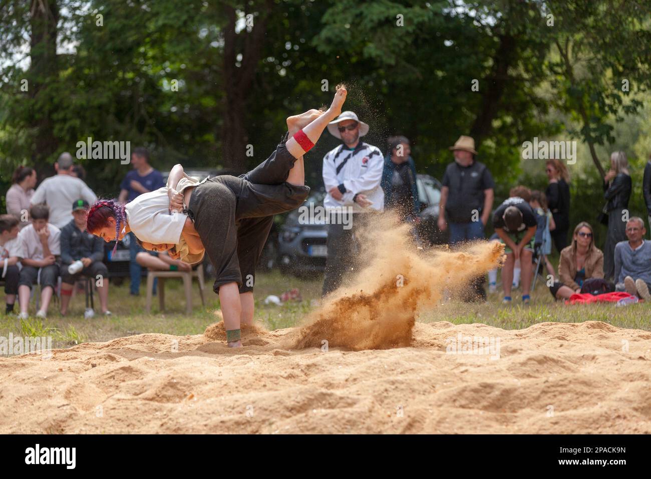 Pleyber-Christ, France - May 29 2022: Two young women practicing Breton wrestling (gouren) taking place on sawdust. Stock Photo