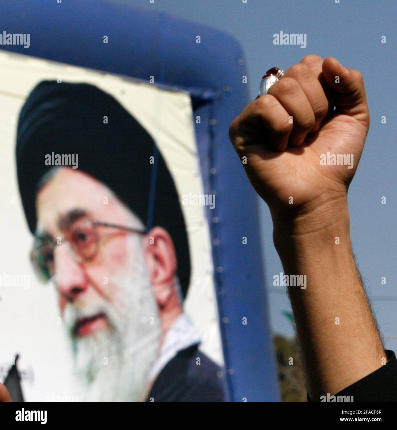 In front of a mural of Iranian supreme leader Ayatollah Ali Khamenei
