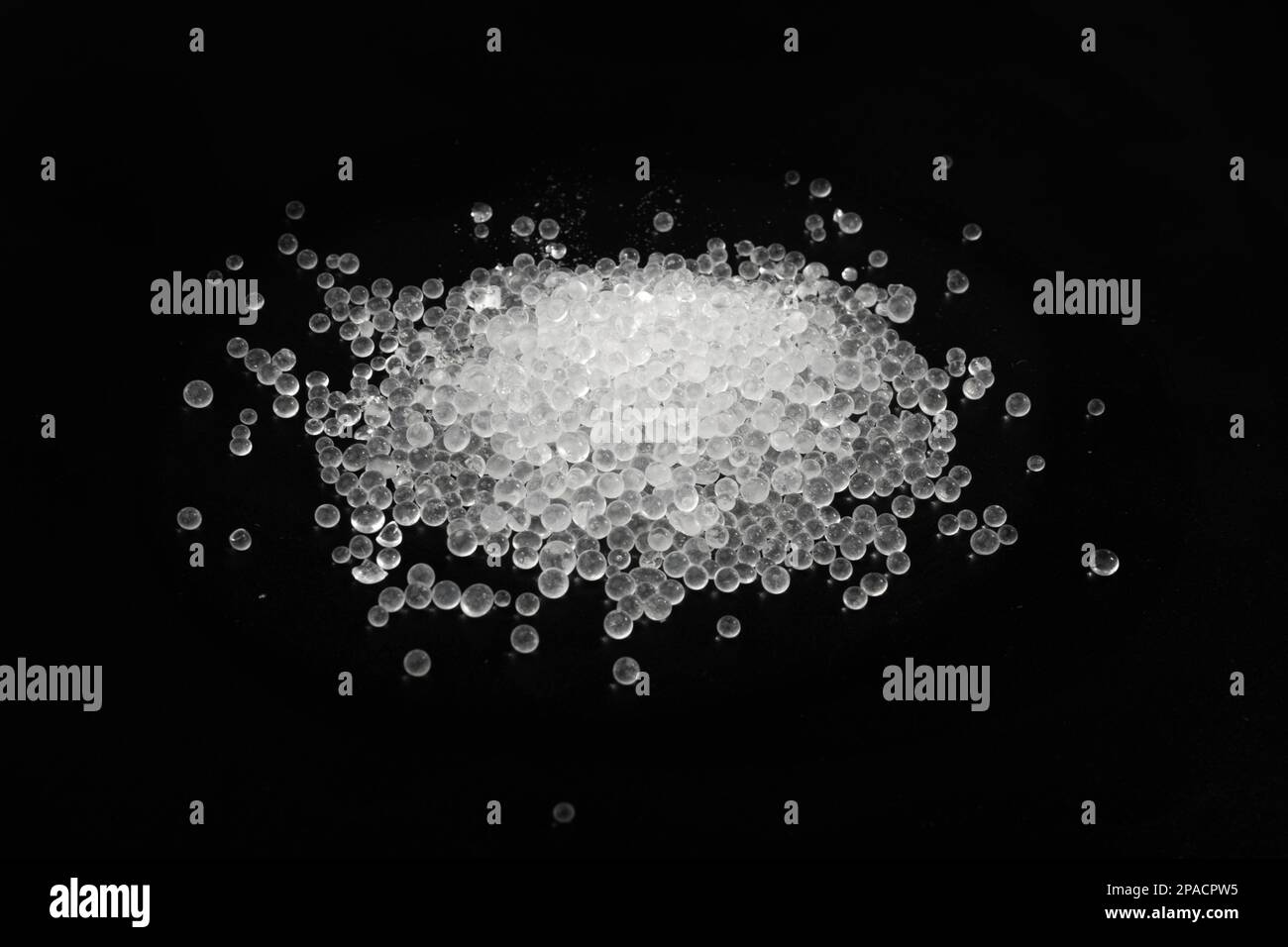 Desiccant Silica Gel Adsorbent Crystals on Black Background Top View
