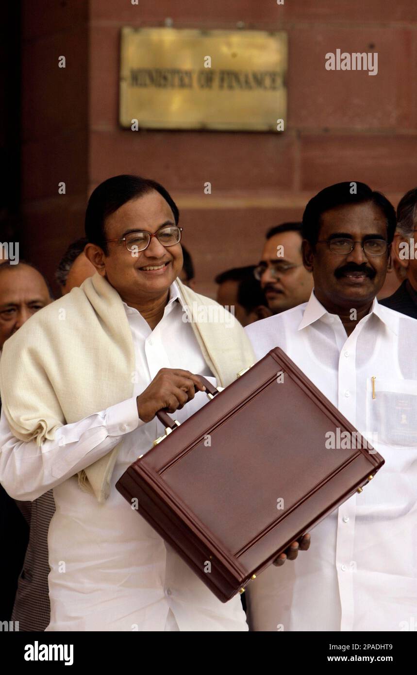 Indian Finance Minister P. Chidambaram, left, holds up his briefcase with budget materials as he walks out of the ministry building to present the annual budget in New Delhi, India, Friday Feb. 29, 2008. (AP Photo/Saurabh Das) Stock Photo