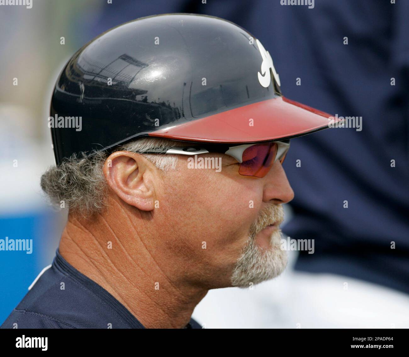 While wearing a batting helmet, Atlanta Braves coach Glenn Hubbard