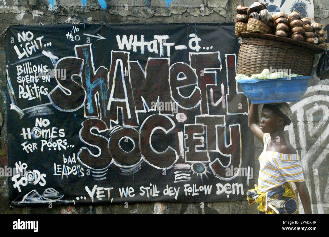 **ADVANCE FOR** Fish seller Sekinat Bolaji walks past a sign written in