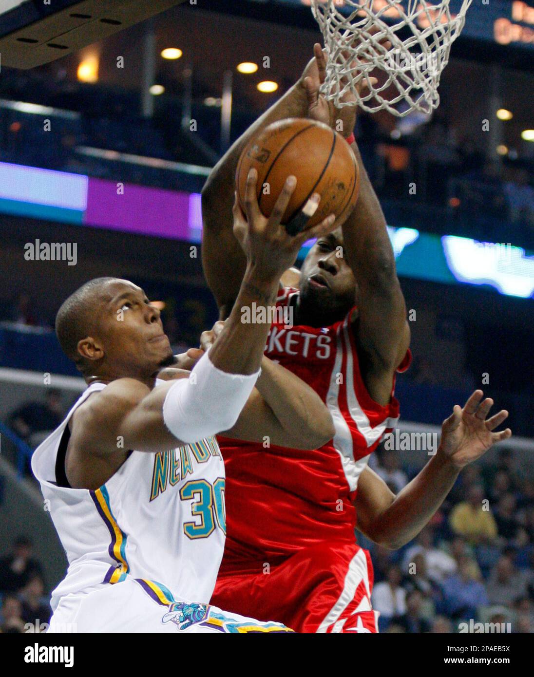 New Orleans Hornets forward David West, left, goes up for a shot as he ...