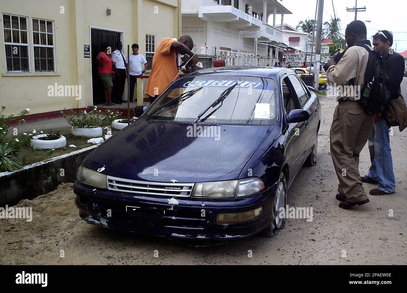 News reporters approach to the bullet-ridden car of Guyanese miner Dexter  Adrian in front of the Police Station of Bartica, Guyana, Monday, Feb. 18,  2008. Adrian is one of twelve people, including