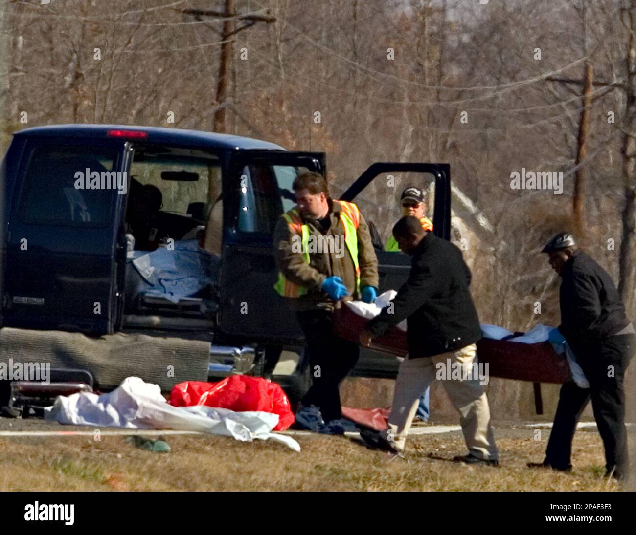 Emergency personnel carry the body of a victim involved in a car crash