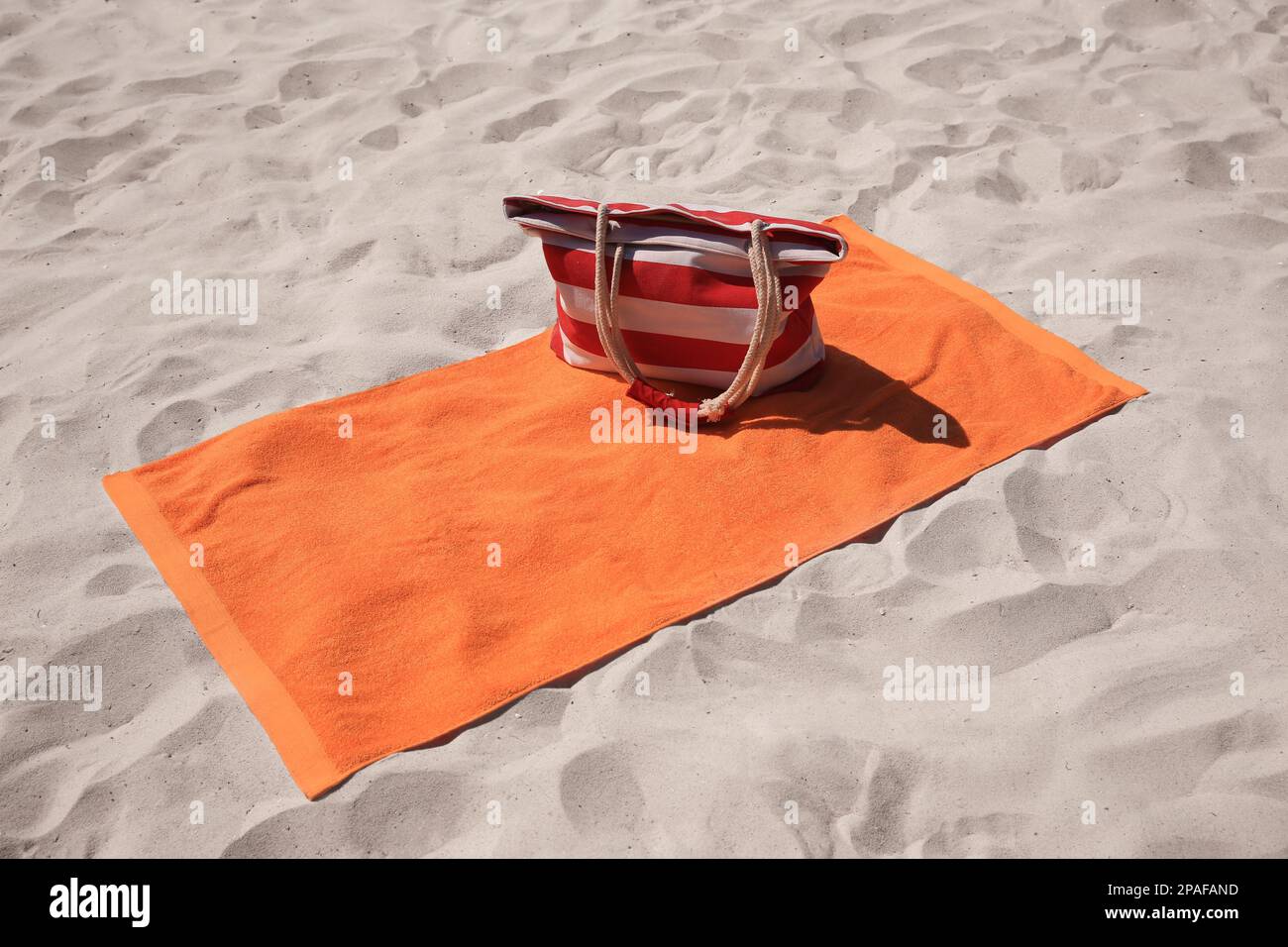 Soft orange beach towel and bag on sand Stock Photo Alamy