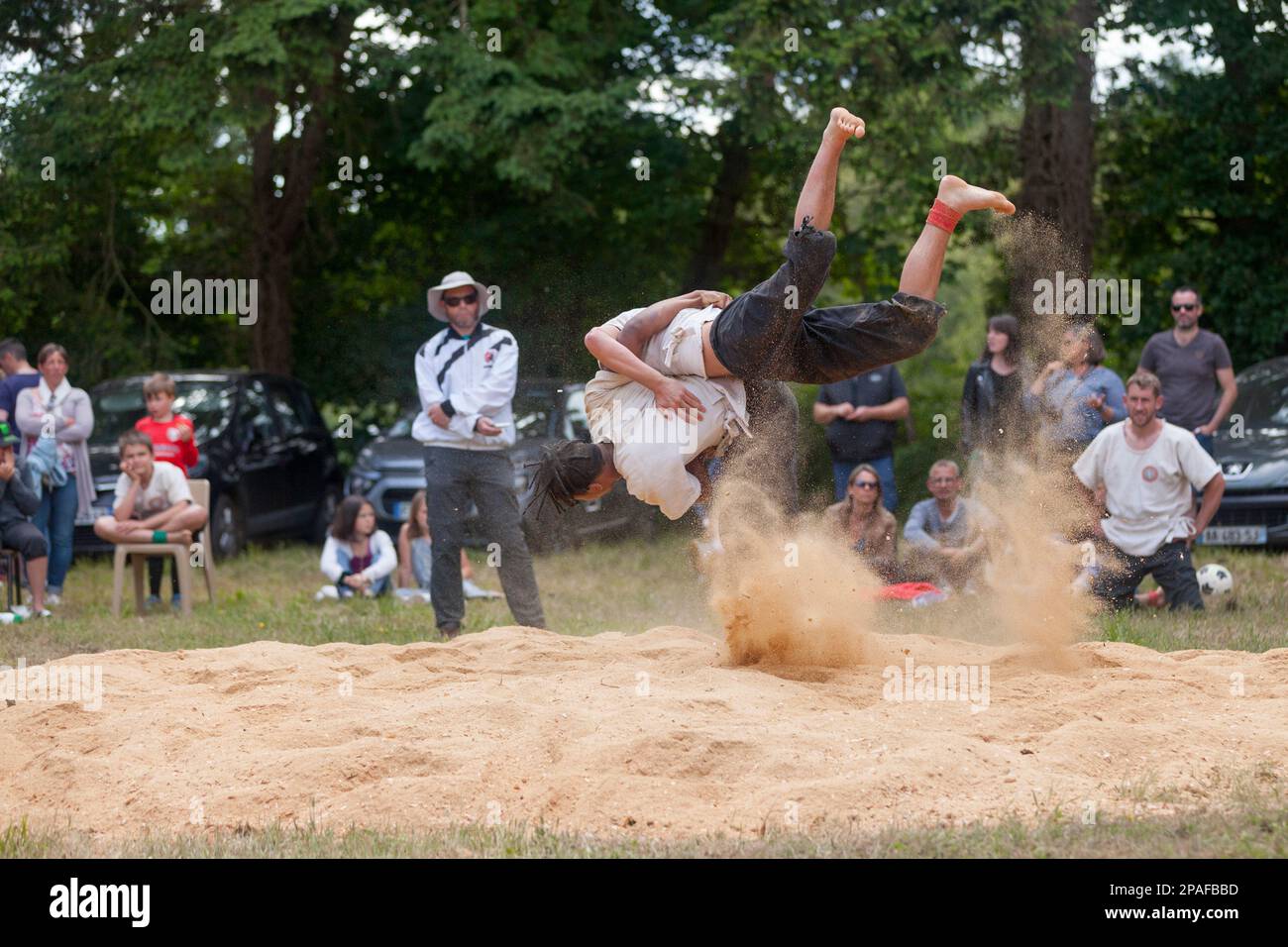 Pleyber-Christ, France - May 29 2022: Two young men practicing Breton wrestling (gouren) taking place on sawdust. Stock Photo