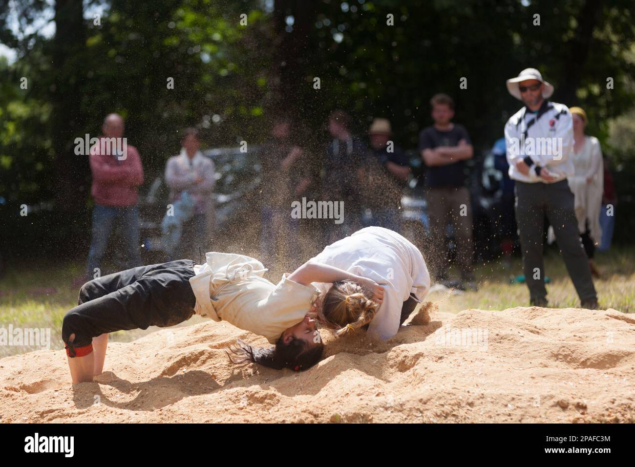 Pleyber-Christ, France - May 29 2022: Two young women practicing Breton wrestling (gouren) taking place on sawdust. Stock Photo