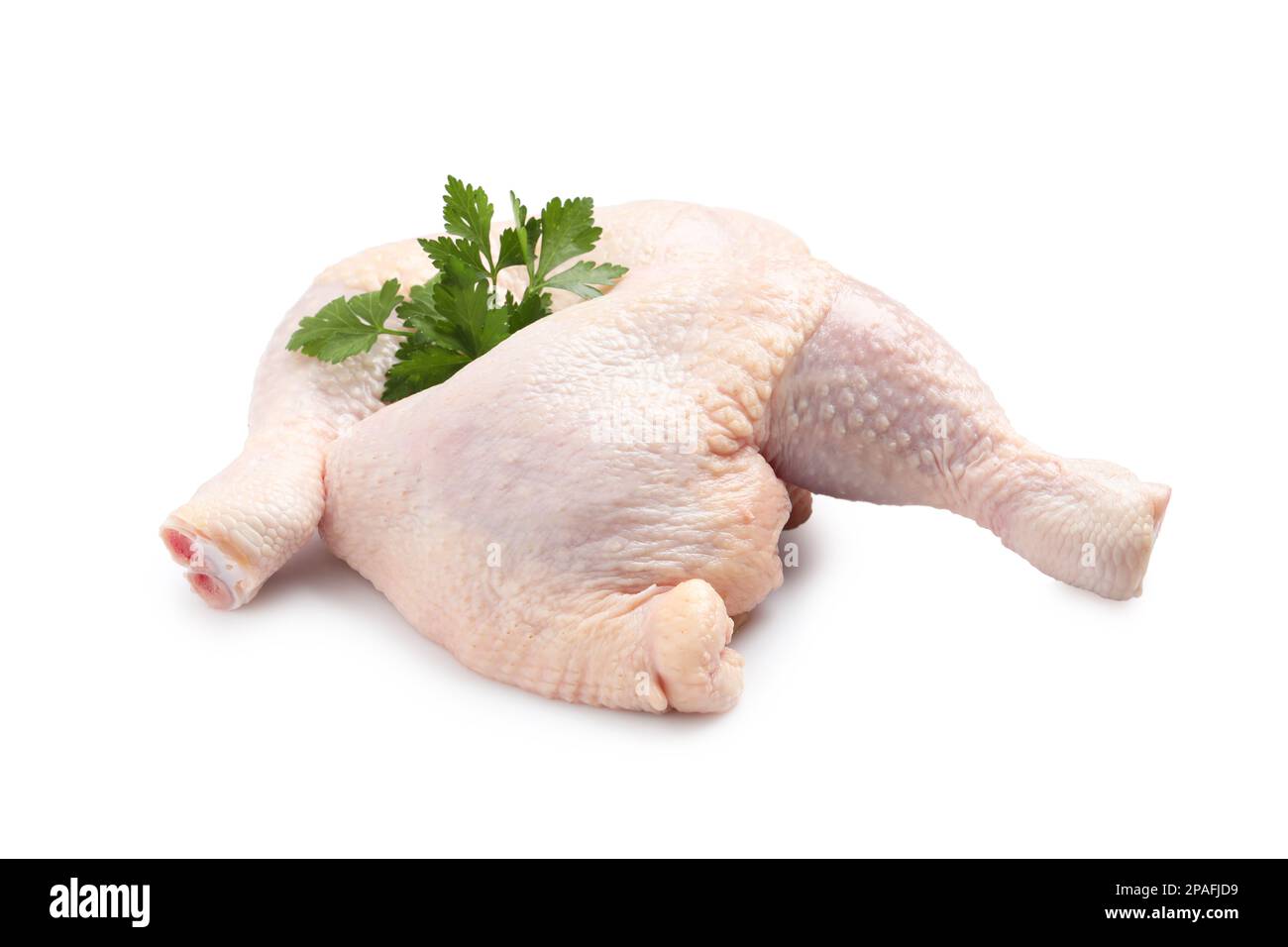 Raw chicken leg quarters with parsley on white background Stock Photo