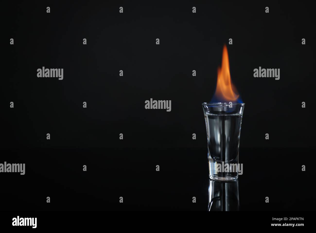 Flaming vodka in shot glass on black background, space for text Stock Photo  - Alamy