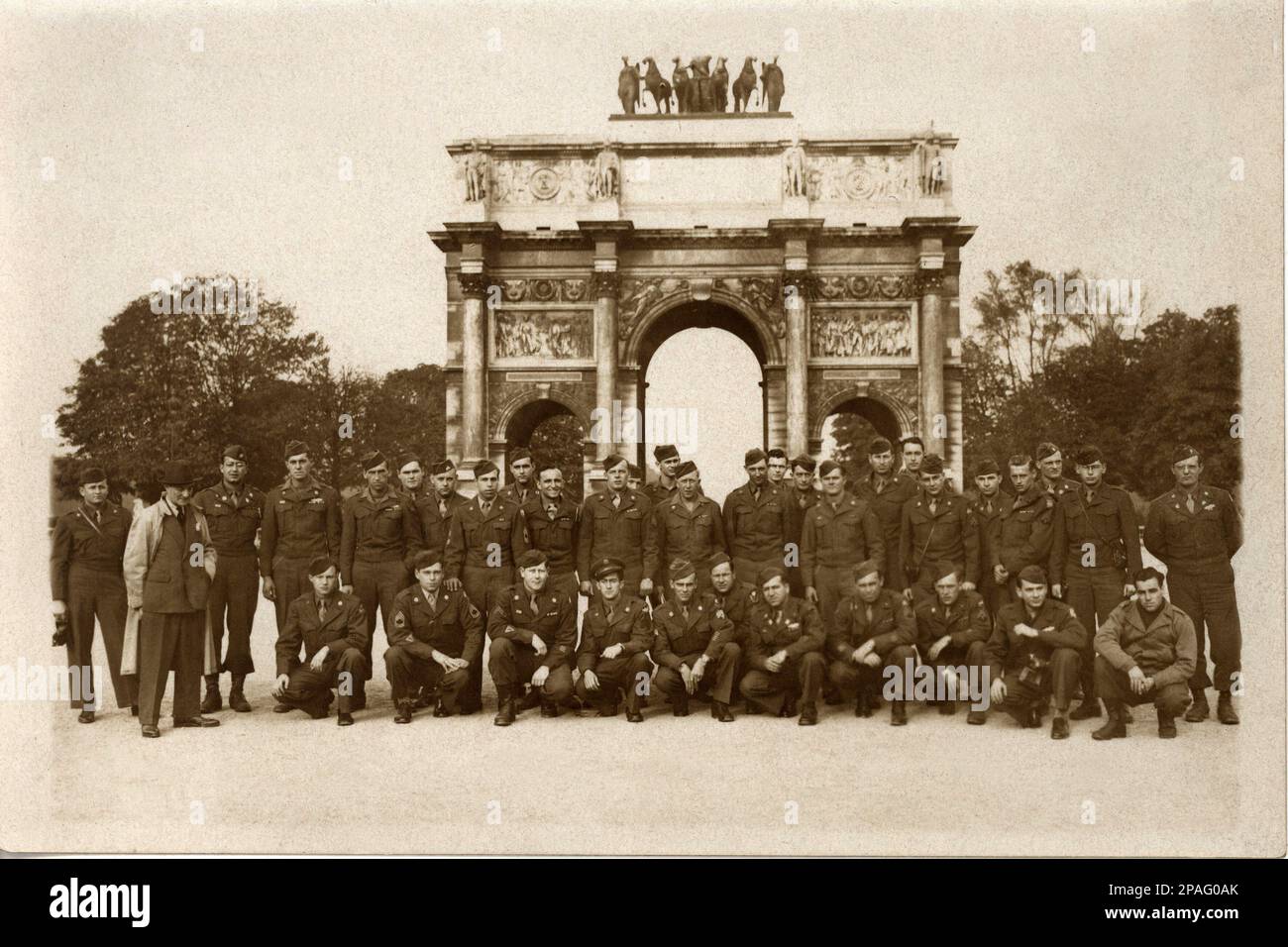 1944 ,  PARIS , FRANCE  : The Allied USA troups posing in front at ARC DU CAROUSEL , near the Louvre museum  . Allied troops start the attack on Paris the day 24 august 1944 . The Arc de Triomphe du Carrousel ( architects Percier and Fontaine ) was built between 1806 and 1808 by Napoleon I Bonaparte following the model of the Arc of Constantine in Rome. The two arches built by Napoleon - Arc de Triomphe du Carrousel and the Arc de Triomphe at Etoile, were to commemorate his victories, and the grand army who had won them .  - PARIGI - FRANCIA - FOTO STORICHE - HISTORY PHOTOS - Arco di Trionfo Stock Photo