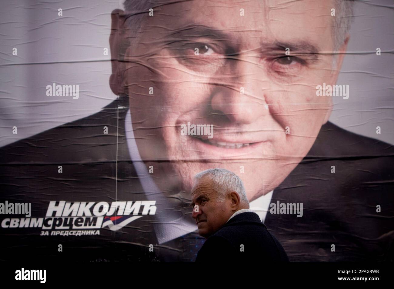 An ethnic Serb man stand in front of presidential elections poster of ...