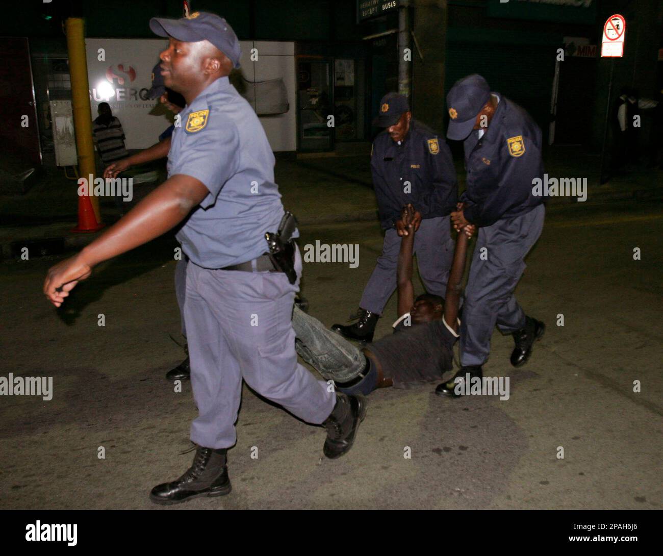 Police officers carry a man as they conduct a raid on the Central Methodist Church in downtown Johannesburg, Thursday, Jan. 31, 2008. The church has become a haven for homeless people, mainly refugees from neighboring Zimbabwe, who have sought shelter inside the place of worship. (AP Photo/Denis Farrell) Stock Photo