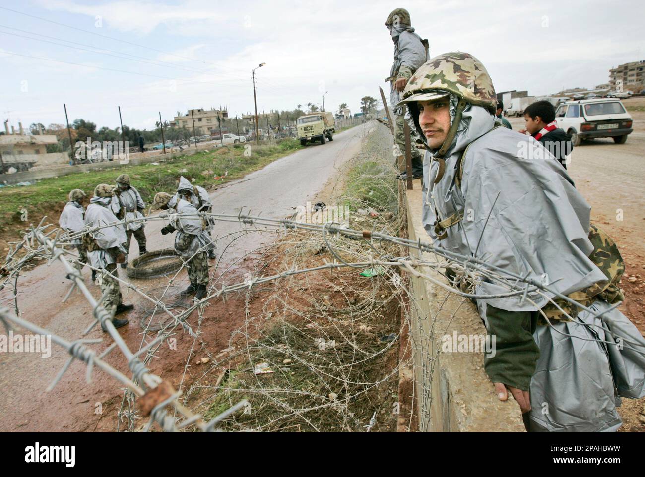 Members of the Egyptian forces repair part of the breached border wall ...
