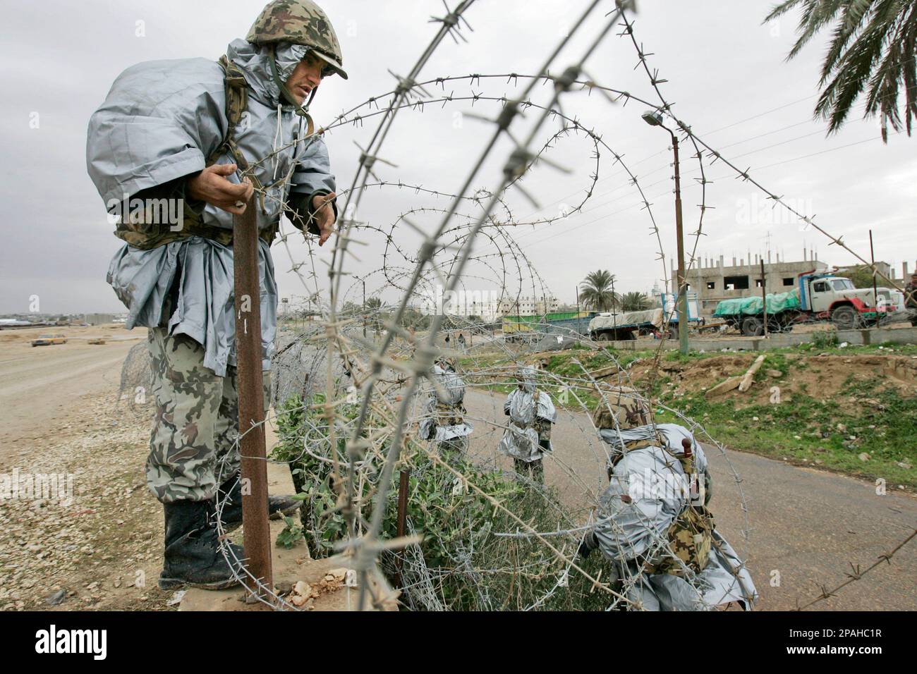 Members of the Egyptian border forces repair part of the breached ...