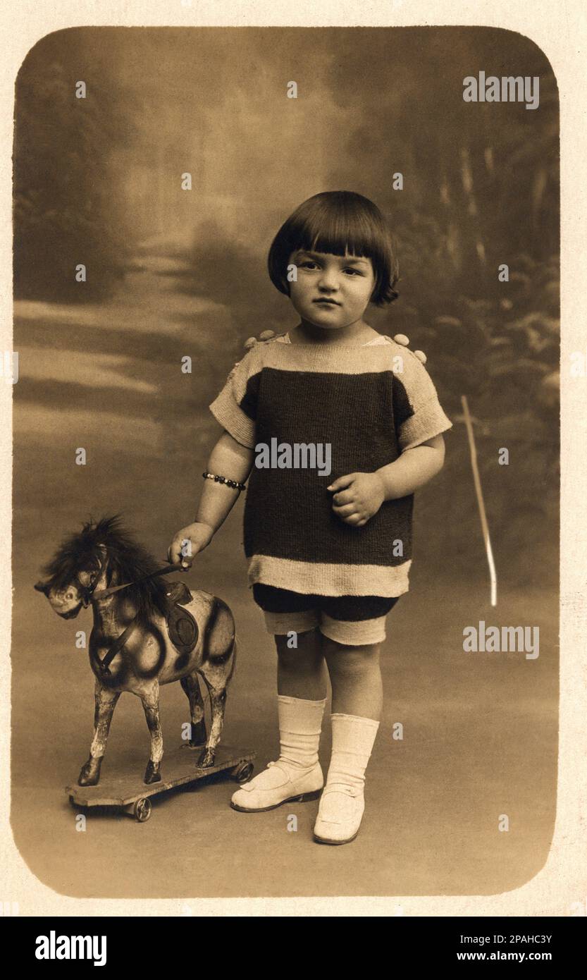 1925 ca , France : A child with  a little toy horse - TOYS - giocattolo - giocattoli  - FOTO STORICHE - HISTORY PHOTOS - cavallo - cavalluccio -    - FRANCIA -  Bebé - BAMBINO - BAMBINI - CHILDREN - BAMBINA - BABY - ANNI VENTI - 20's - '20 - little girl - bracelet - braccialetto - scarpe - shoes  - PONY ---- Archivio GBB Stock Photo